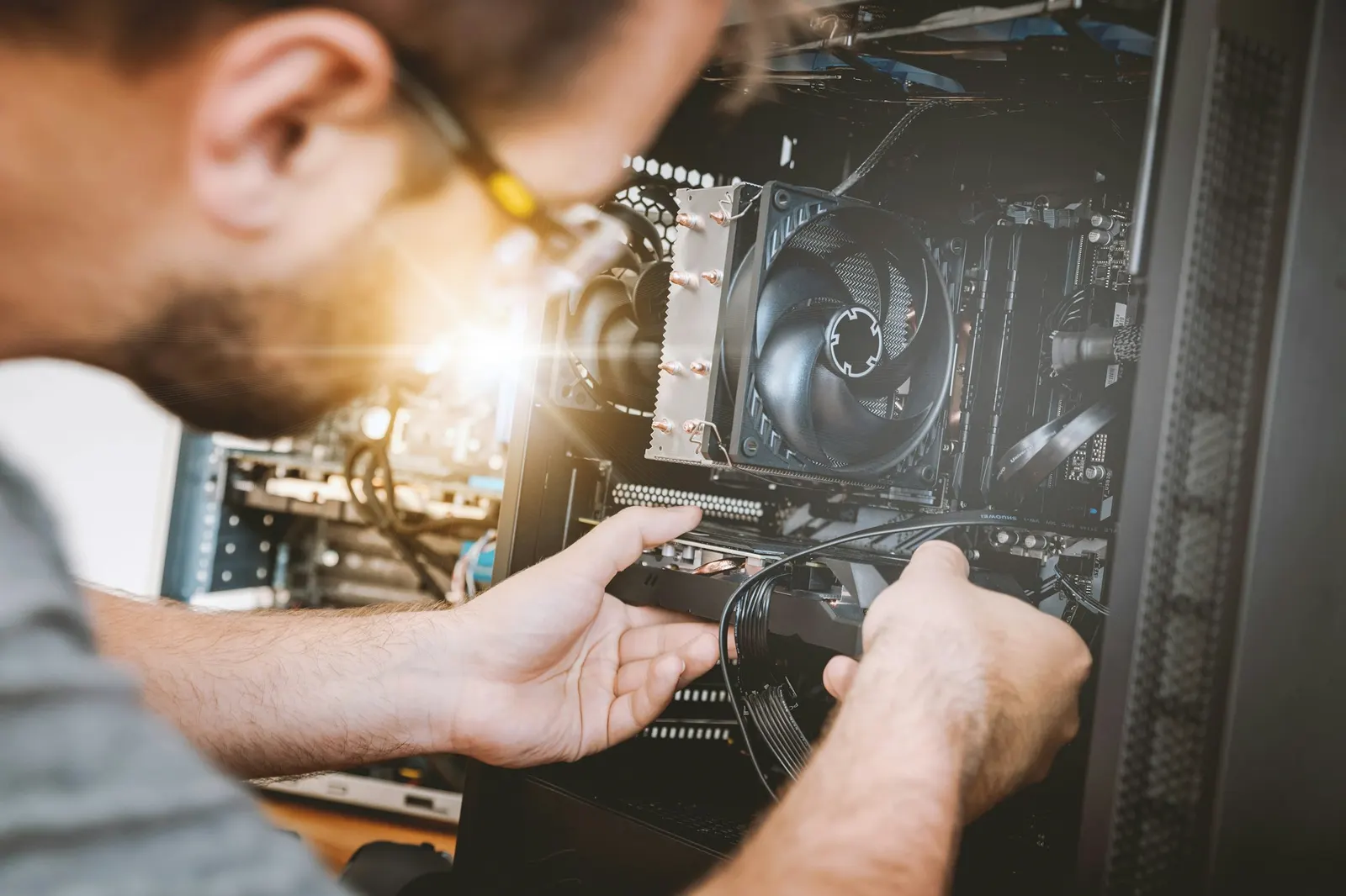 Técnico encaixando uma placa de vídeo num computador de mesa